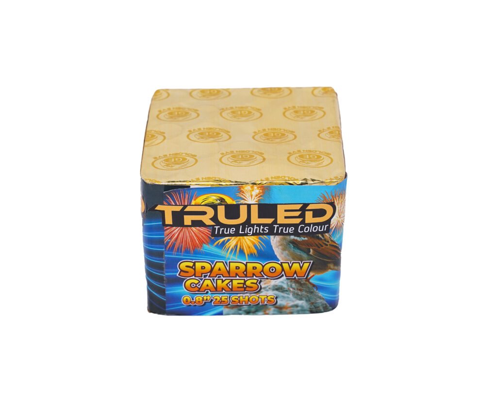 Top view of a fireworks cake box with a gold foil lid and bold colorful graphics showing fireworks and the text SPARROW CAKES on the front panel.